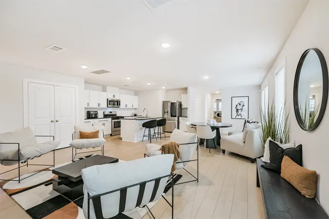 a living room with furniture a rug and white walls