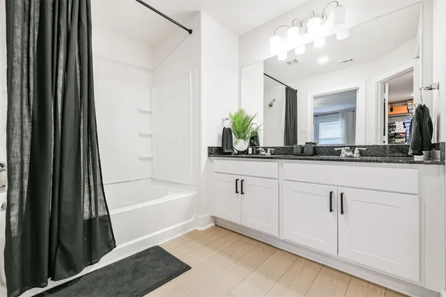 a bathroom with a tub sink and mirror