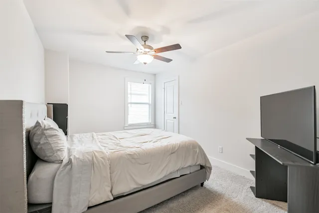 a bedroom with a bed and a ceiling fan