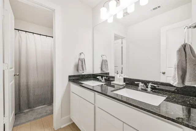 a bathroom with a double vanity sink and a mirror