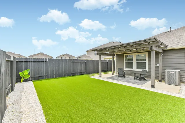 a view of a house with backyard and sitting area