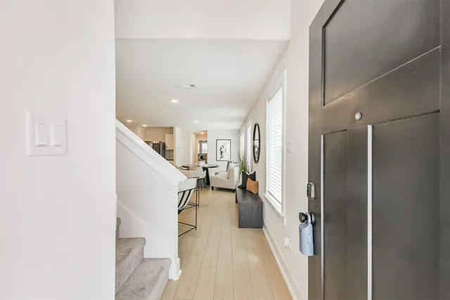 a view of a hallway with white walls and stairs