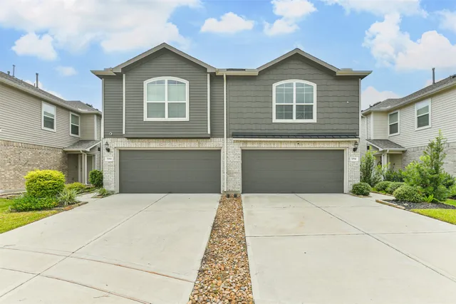 a front view of a house with yard and parking