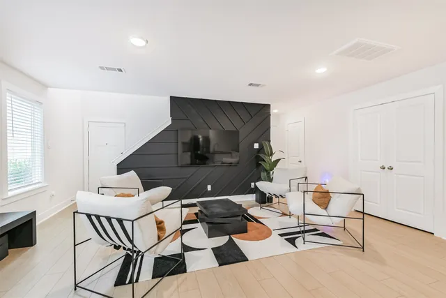 a living room with furniture and a wooden floor