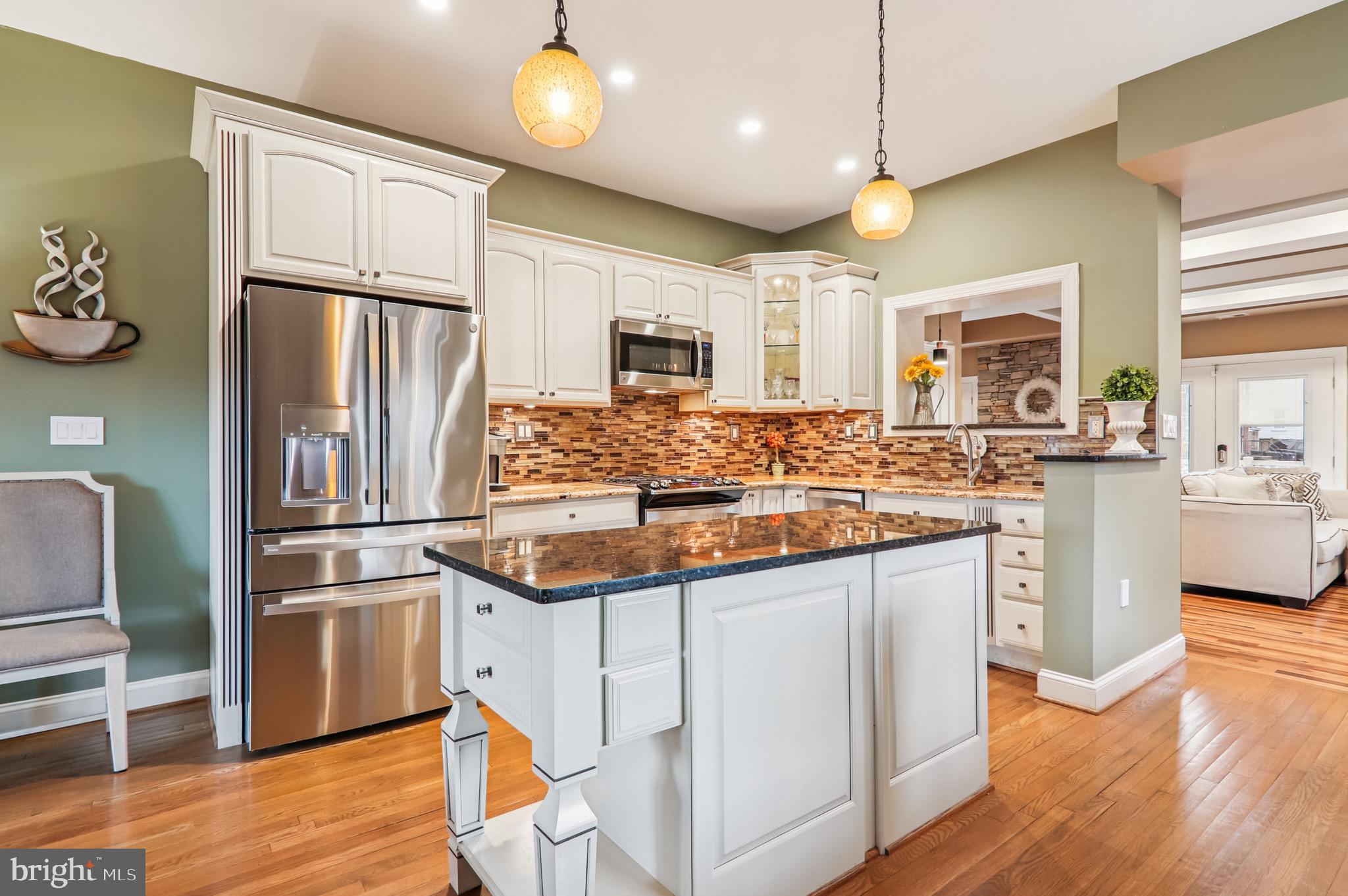 4200 19th Street Northeast Washington, DC 20018 - Photo 6 of 34 a kitchen with stainless steel appliances granite countertop a refrigerator a stove a sink and white cabinets with wooden floor