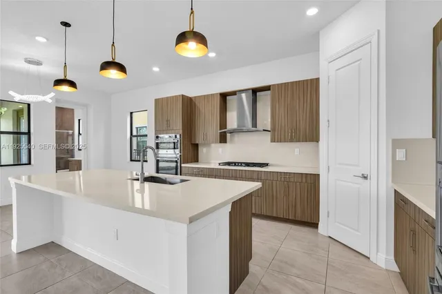 a kitchen with stainless steel appliances granite countertop a sink a stove and a refrigerator