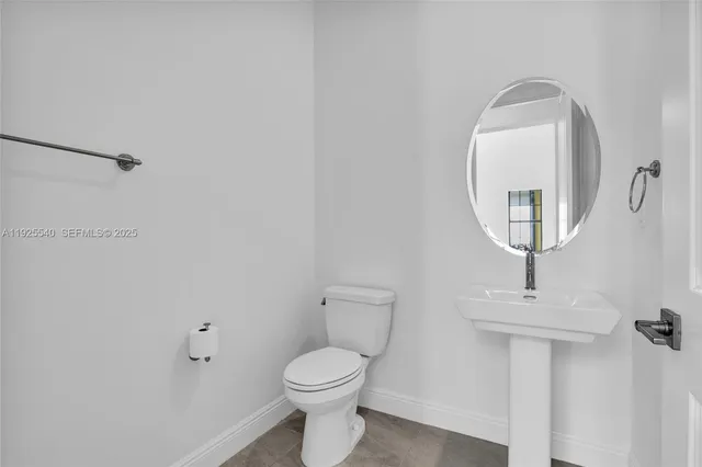 a bathroom with a toilet a sink and mirror