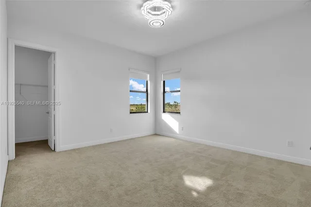 an empty room with windows and closet