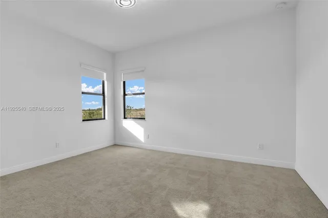 a view of an empty room with window and stairs
