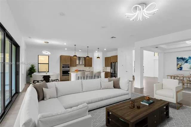 a living room with furniture a large window and a chandelier