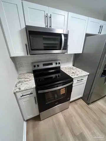 a stove top oven sitting inside of a kitchen