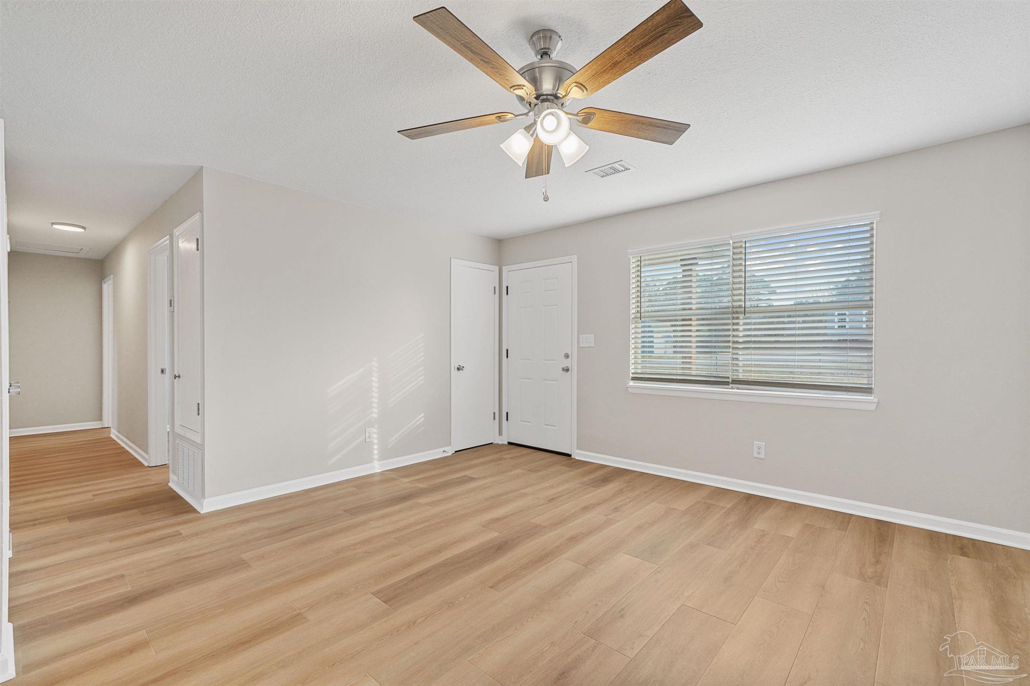 284 Dolan Drive Cantonment, FL 32533 - Photo 13 of 32 an empty room with wooden floor chandelier fan and windows