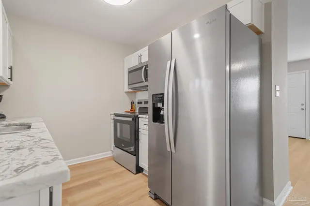 a kitchen with stainless steel appliances granite countertop a refrigerator and a stove