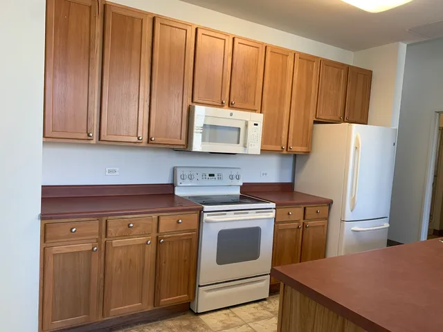 a kitchen with appliances a sink and cabinets
