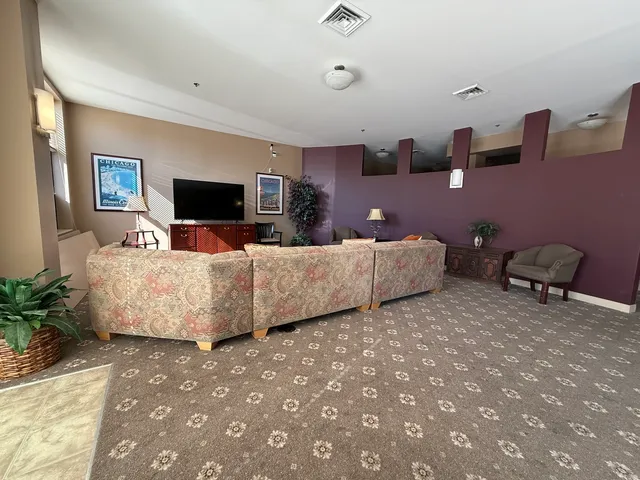 a living room with furniture a large window and wooden floor