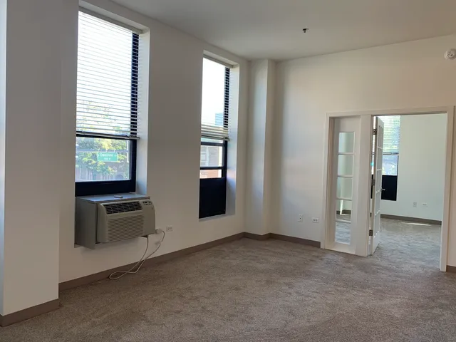 a view of an empty room with a window and fire place