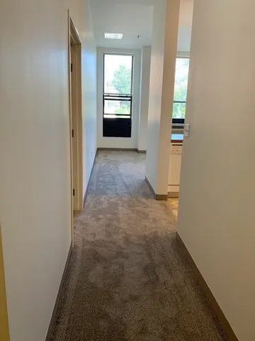 a view of a hallway with wooden shelves