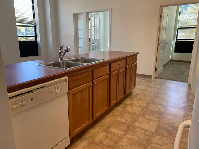 a room with stainless steel appliances a sink and a large mirror
