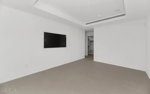 a view of an empty room with wooden floor and a flat screen tv
