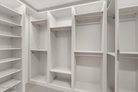 a view of walk in closet with empty racks