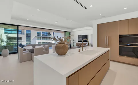 a kitchen with a stove a refrigerator and a view of living room