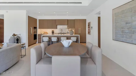 a living room with stainless steel appliances furniture a window and kitchen view