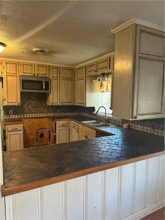 a kitchen with granite countertop a sink and cabinets