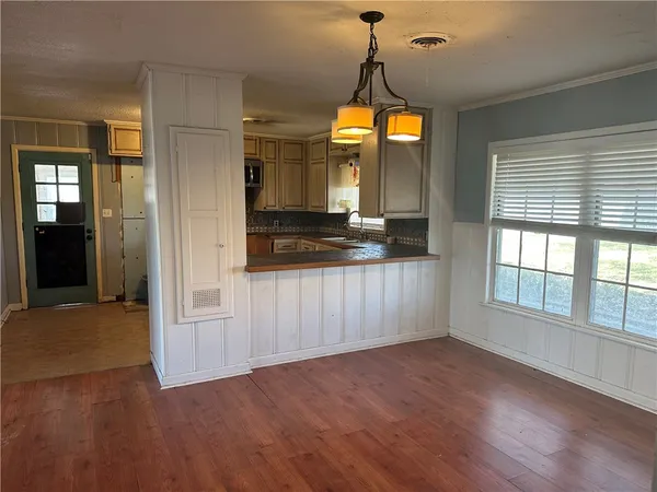 a view of a kitchen with a sink and wooden floor