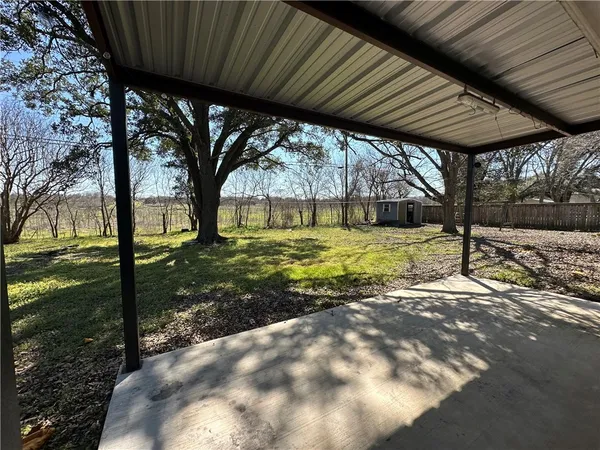a view of a backyard with table and chairs under an umbrella