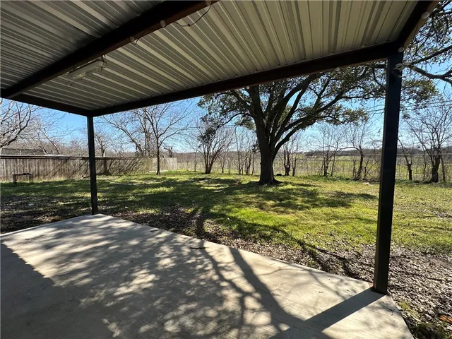 a view of a backyard with table and chairs under an umbrella