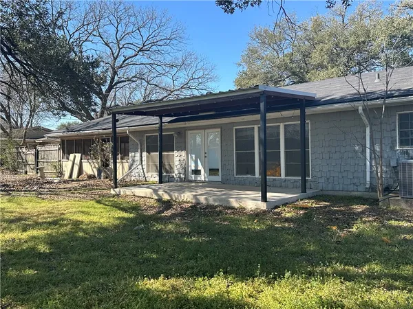 a view of a house with backyard and sitting area