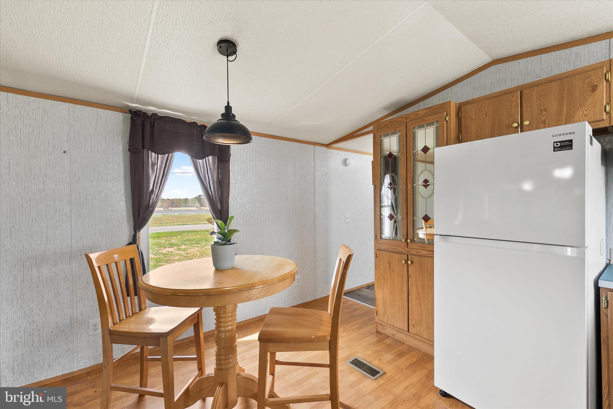 36999 Hudson Road Selbyville, DE 19975 - Photo 11 of 28 a kitchen with a refrigerator a table and chairs