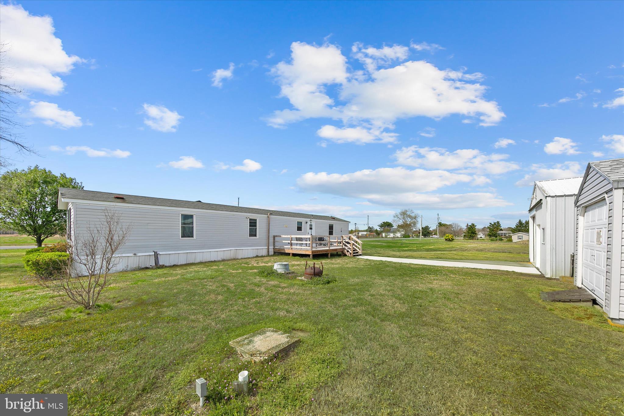 36999 Hudson Road Selbyville, DE 19975 - Photo 24 of 28 a view of a big yard with an outdoor seating and garage