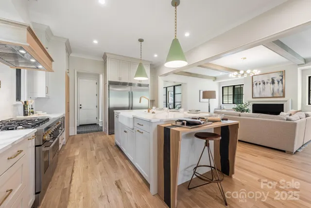 a kitchen with stainless steel appliances a dining table chairs stove and refrigerator