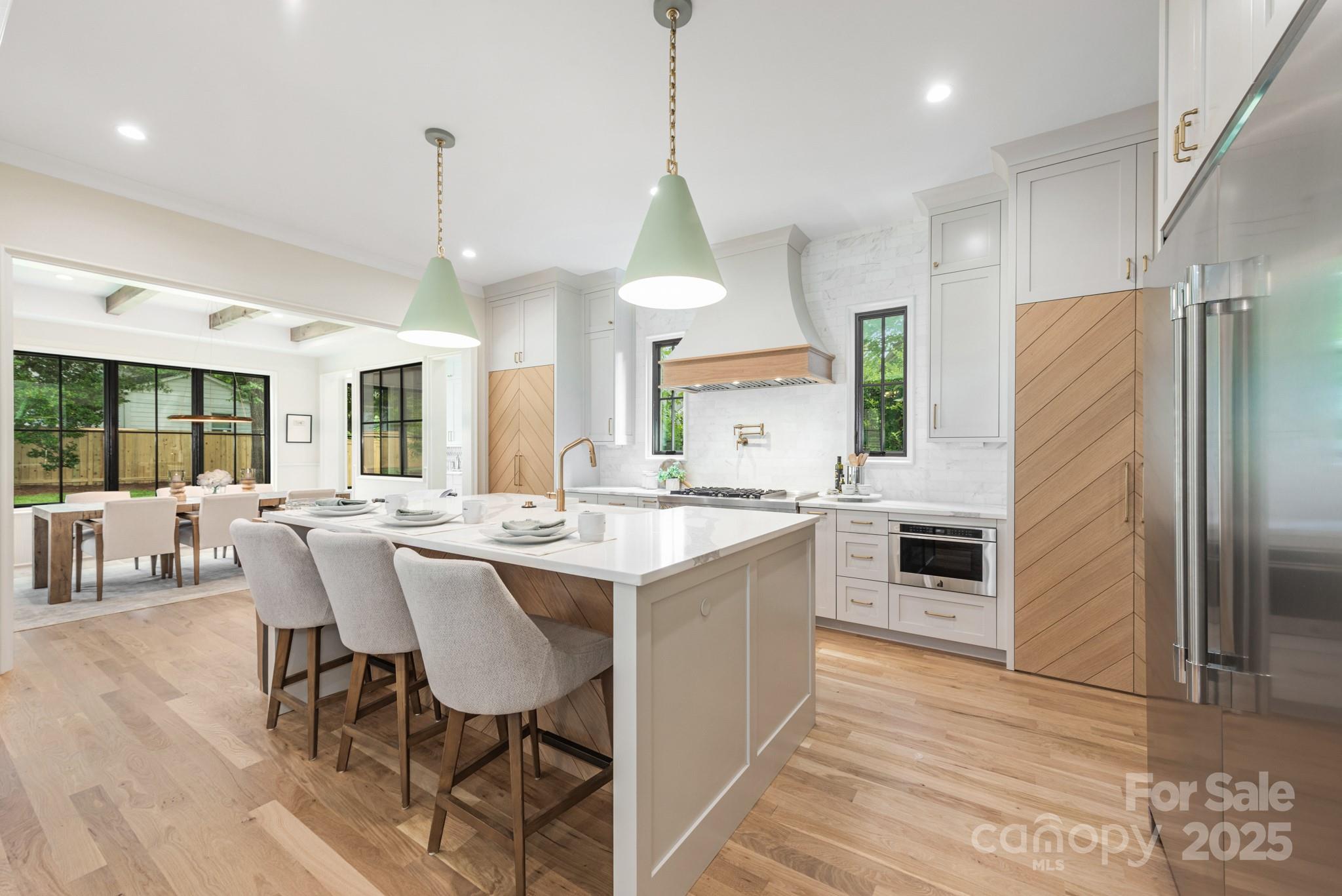 4021 Ridgecrest Avenue Charlotte, NC 28211 - Photo 15 of 47 a kitchen with stainless steel appliances a dining table chairs stove and refrigerator
