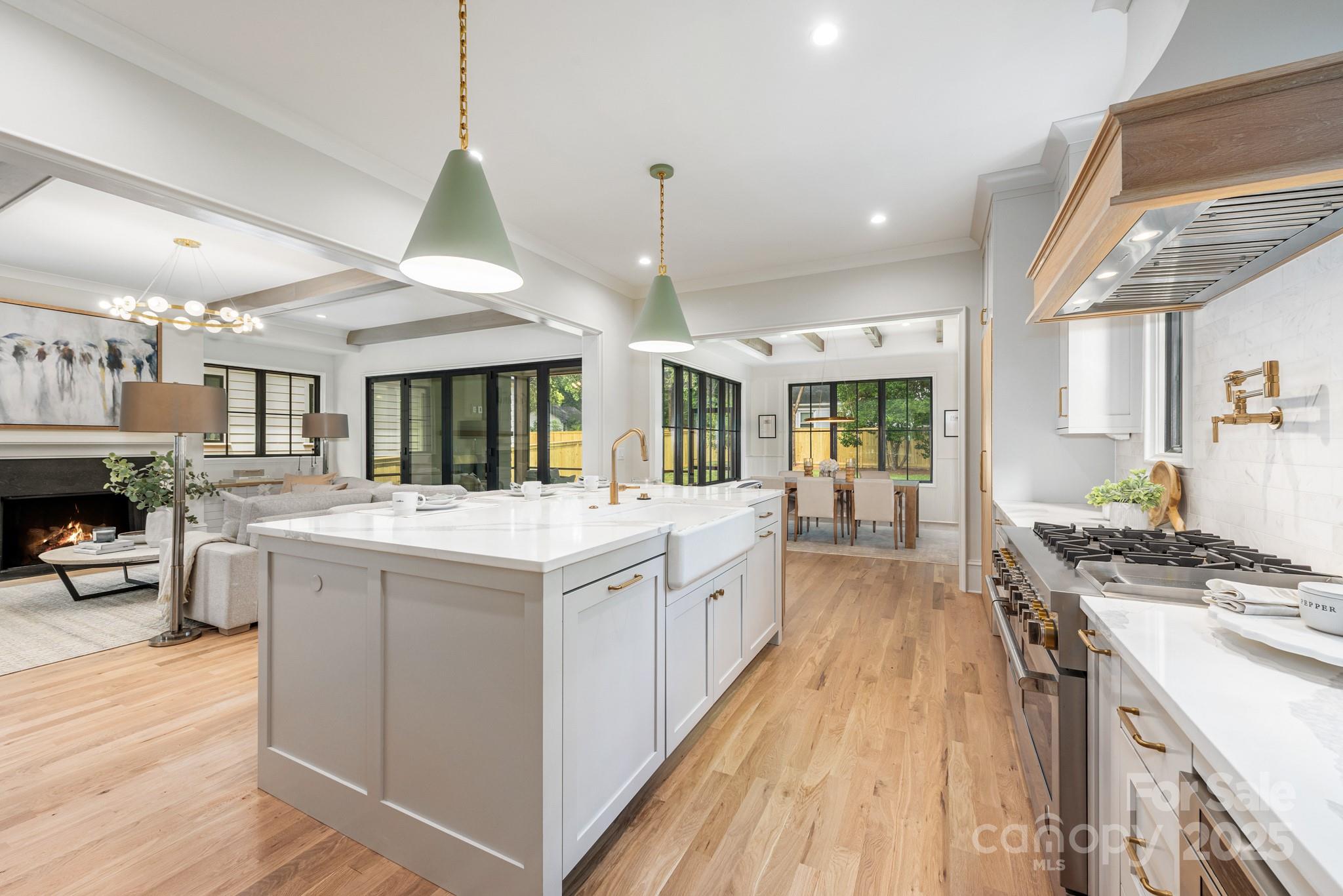 4021 Ridgecrest Avenue Charlotte, NC 28211 - Photo 16 of 47 a large kitchen with kitchen island a stove a sink dishwasher a dining table and chairs with wooden floor