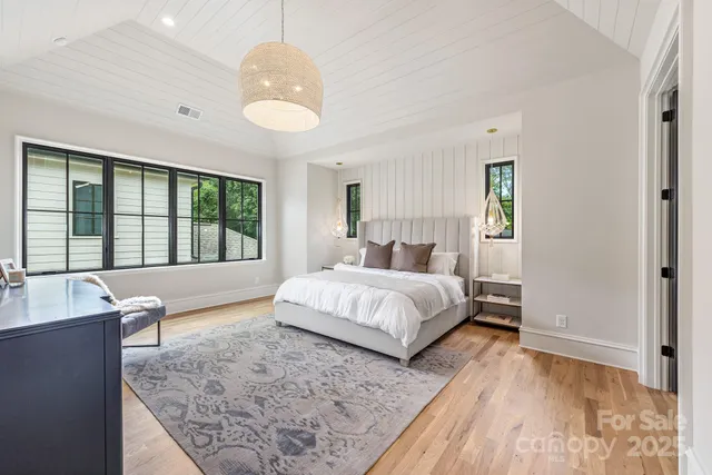 a bedroom with a large bed and a chandelier