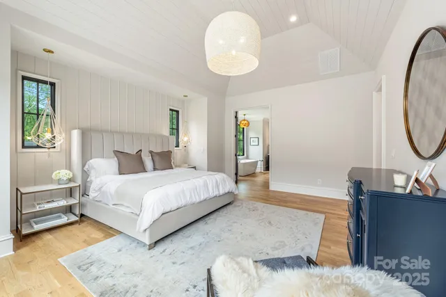 a spacious bathroom with a tub a double vanity sink a mirror and a shower