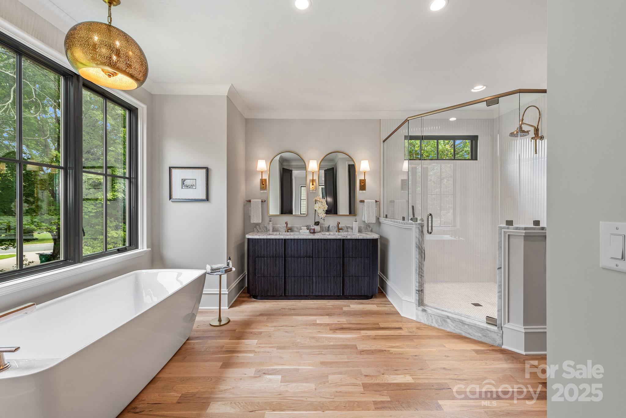4021 Ridgecrest Avenue Charlotte, NC 28211 - Photo 33 of 47 a spacious bathroom with a tub a double vanity sink a mirror and a shower