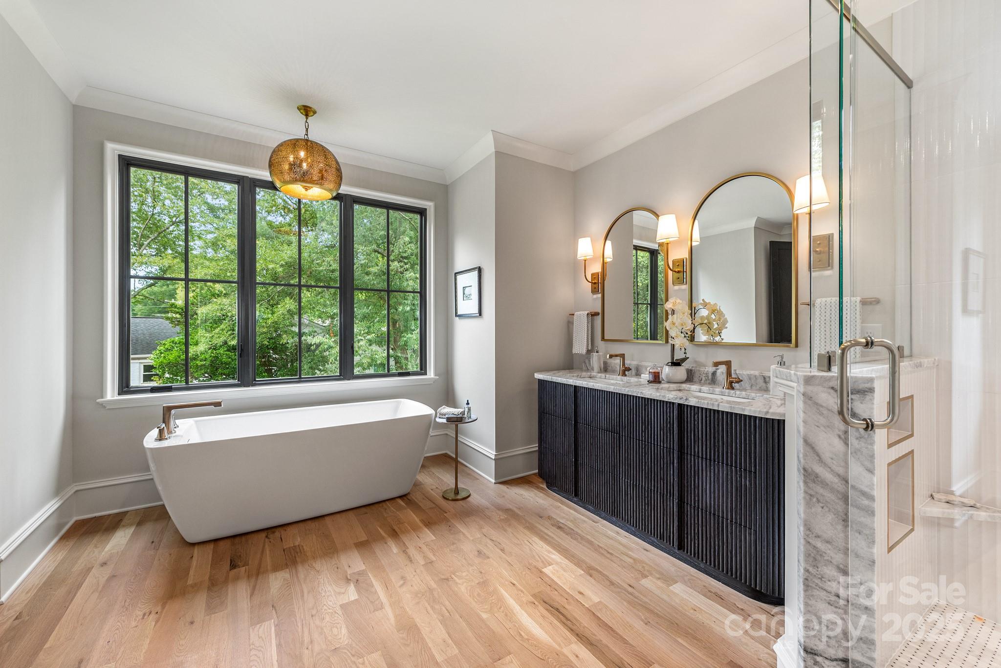 4021 Ridgecrest Avenue Charlotte, NC 28211 - Photo 35 of 47 a spacious bathroom with a double vanity sink a mirror and a bathtub