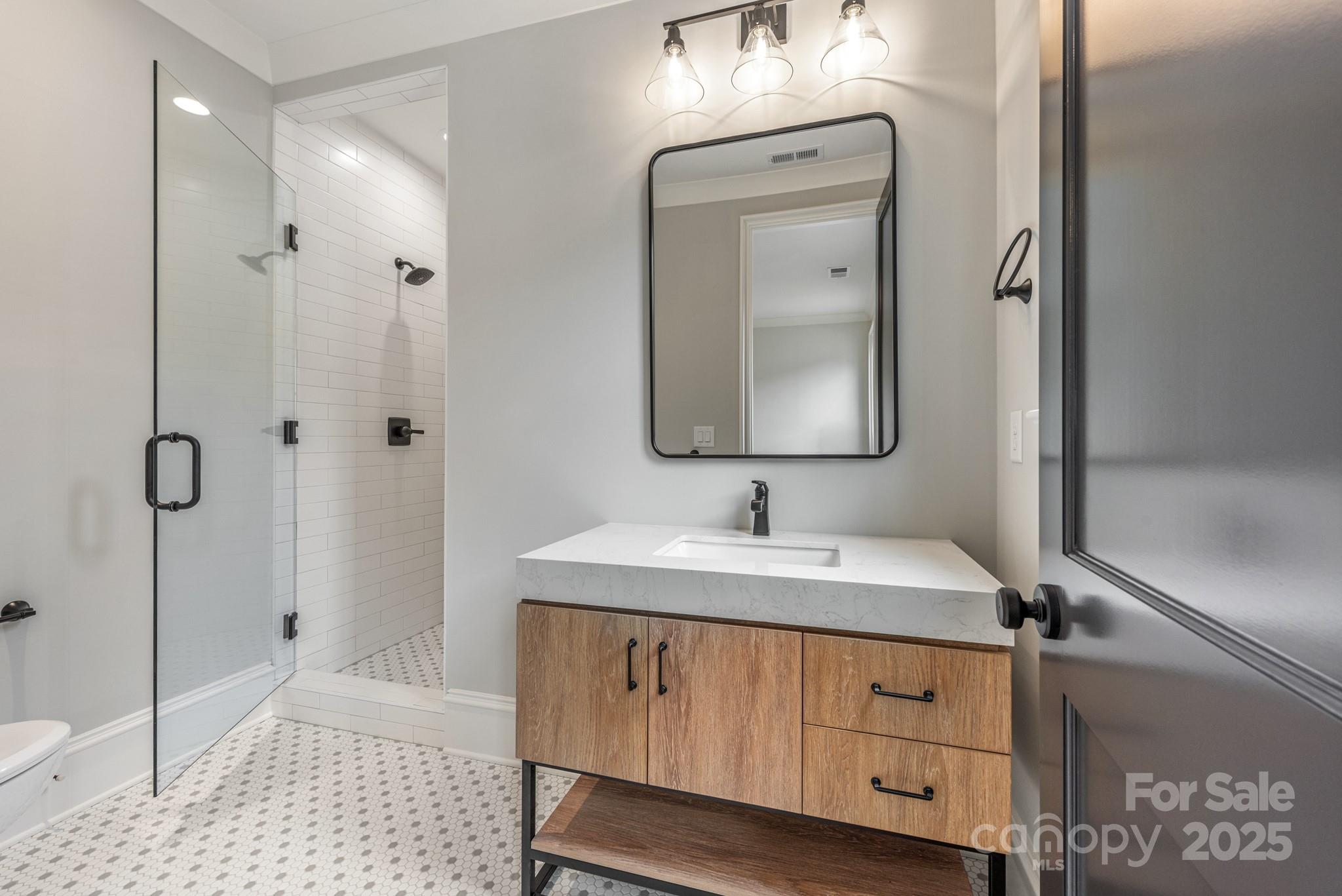 4021 Ridgecrest Avenue Charlotte, NC 28211 - Photo 42 of 47 a bathroom with a sink a light fixture and a mirror