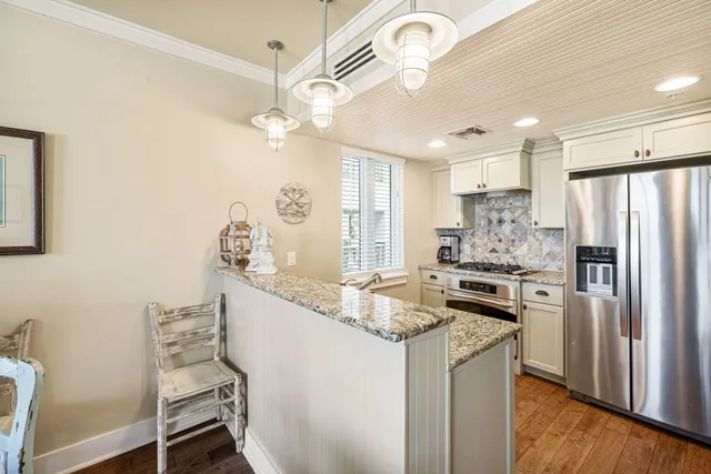 a kitchen with granite countertop a sink appliances cabinets and furniture