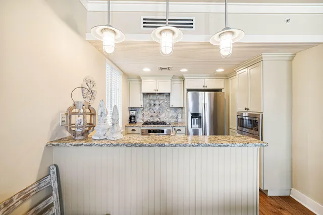 a large kitchen with a chandelier stainless steel appliances and chandelier