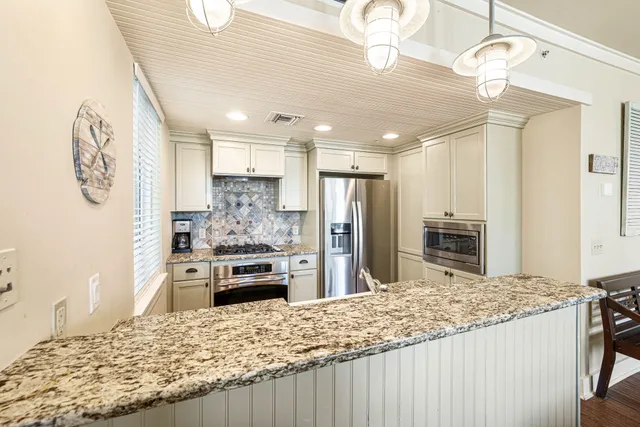 a kitchen with kitchen island granite countertop a stove and refrigerator
