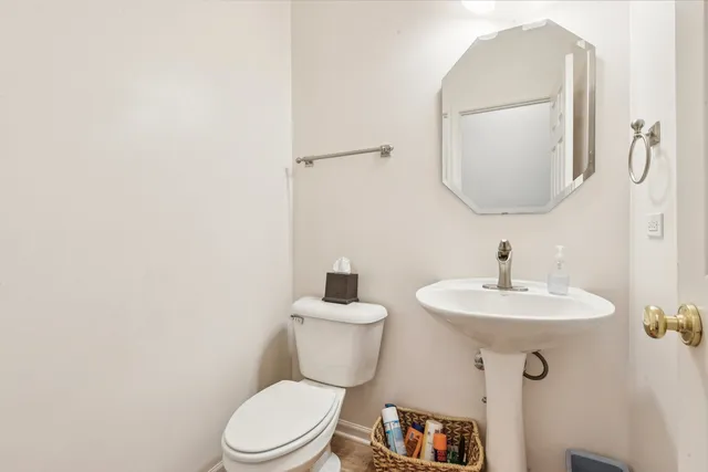 a bathroom with a toilet a sink and mirror