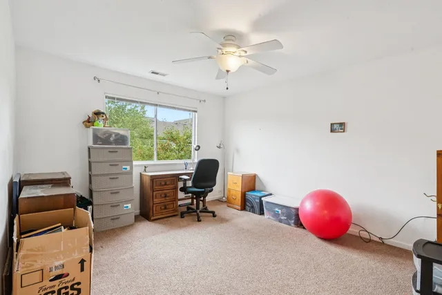 a view of a workspace with furniture and a window