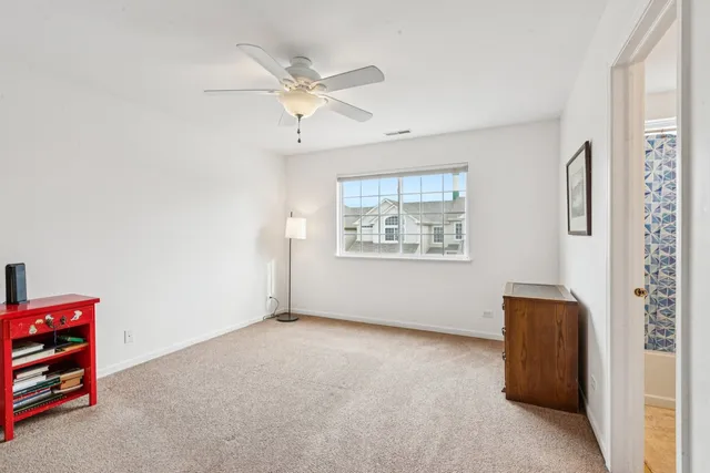 an empty room with windows and fan