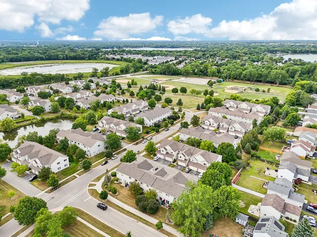 an aerial view of a city with lots of residential buildings and mountain view in back