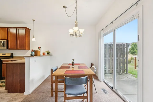 a dining room with furniture a chandelier and window