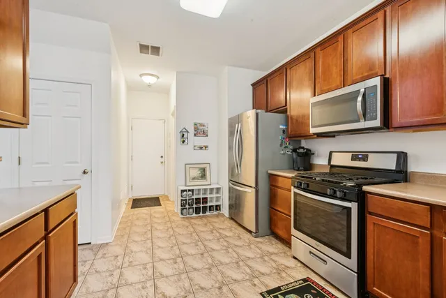 a kitchen with stainless steel appliances granite countertop a refrigerator stove and sink